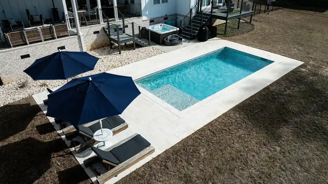 A clean Contemporary Pool Works pool and spa on a sunny afternoon
